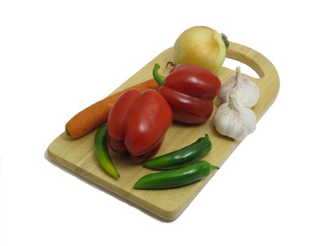 Garlic,onion,pepper,carrot on cutting board isolated on white