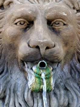 Weather water fountain with a lion theme.