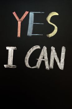 Chalk handwriting of "Yes I Can" on a blackboard