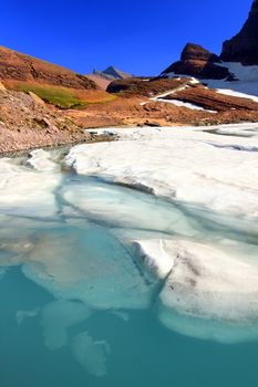 Ice floats in melting water of the Grinnell Glacier in Glacier National Park of Montana.