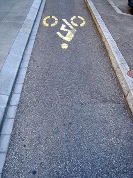 Yellow bicycle track in the asphalt