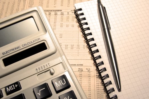 Calculator, pen, notebook and newspaper. Financial concept.