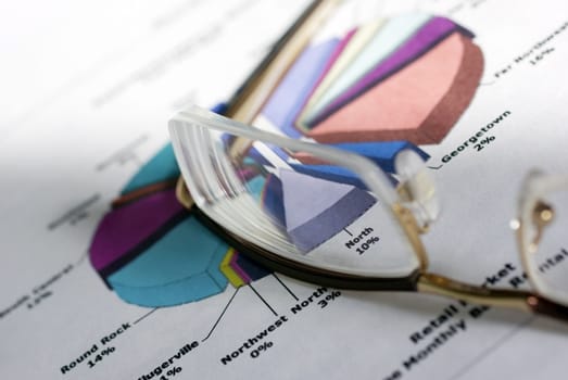 Glasses laying on color diagramm. Financial Concept.