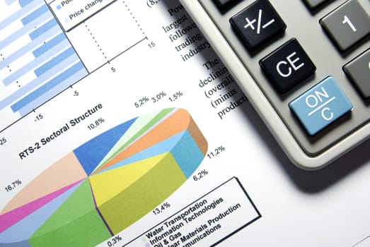 Calculator and printed stock data with diagrams.