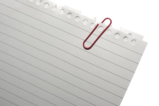 Corner of blank note paper with red paper-clip. Isolated on white. Clipping path.