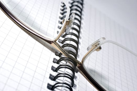 Glasses laying on spiral notebook. Office concept.