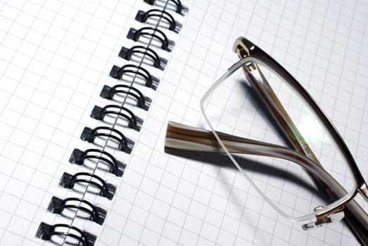 Glasses laying on spiral notebook. Business concept.