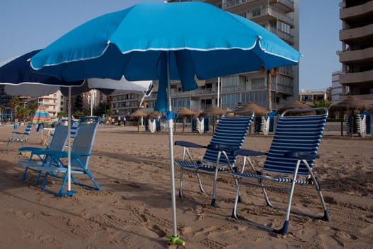 Blue Parasol with chairs at the beach