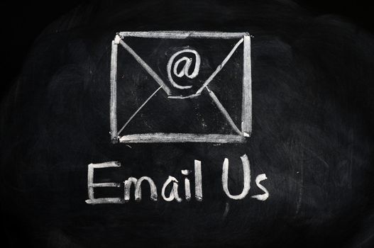 Email us concept with an internet symbol and envelope drawn with chalk on blackboard