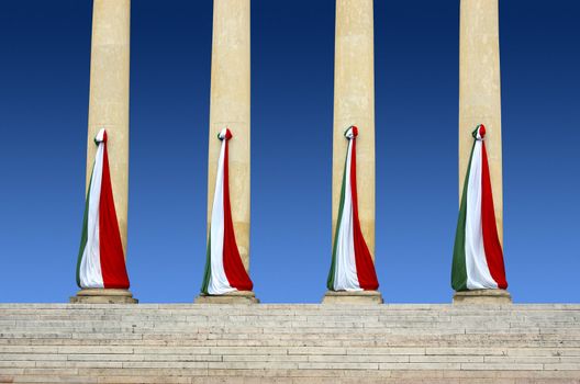 Four Italian flags of stone columns and blue sky