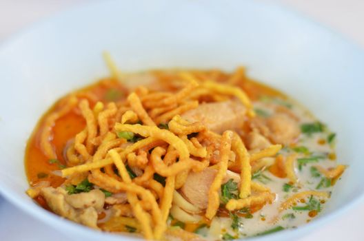 A noodle dish in a yellow curry with chicken. Khao soy a famous northern Thai food. 