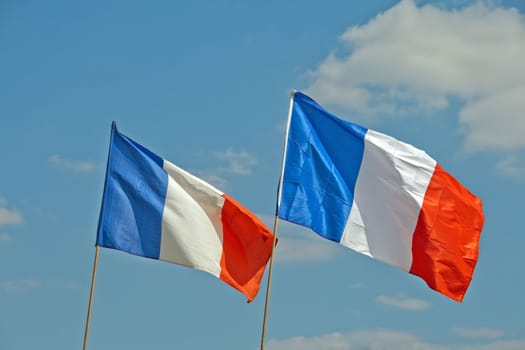 two french flags fluttering in the sky of Paris (France)