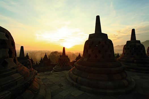 Silhouette of Ancient stupa Borobudur Temple, with sunrise in Yogyakarta, Java, Indonesia.