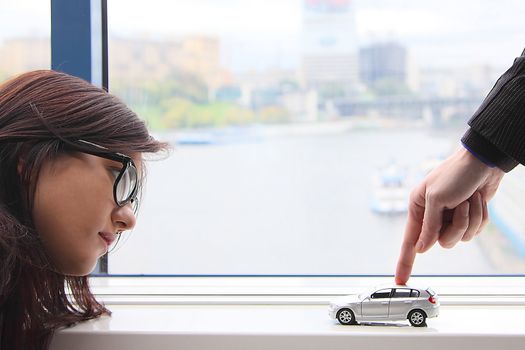 The finger of the businessman moves the toy car
