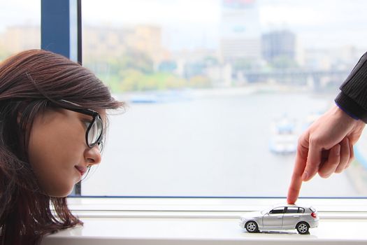 The finger of the businessman moves the toy car