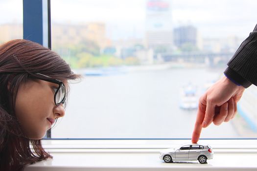 The finger of the businessman moves the toy car