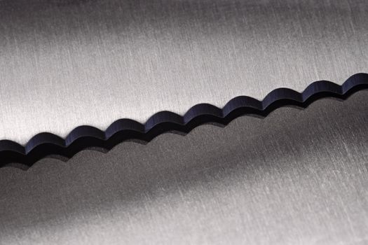 Macro photo of a serrated kitchen knife.