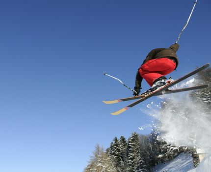 Jumping skier having fun in mountain in winter