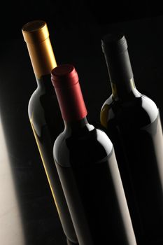 bottles of red and white wine on black background