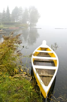 yellow boat in the lake and autumn morning mist