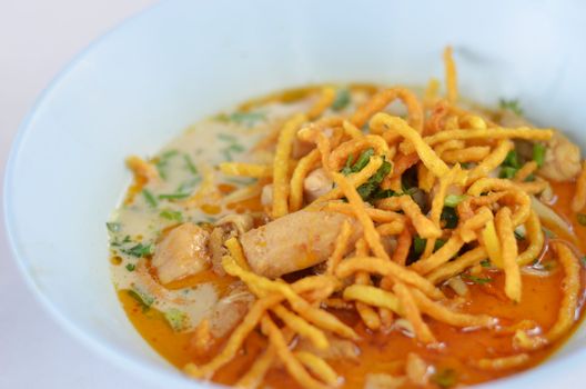 A noodle dish in a yellow curry with chicken. Khao soy a famous northern Thai food. 