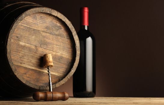 red wine bottle, wodden barrel and corkscrew 