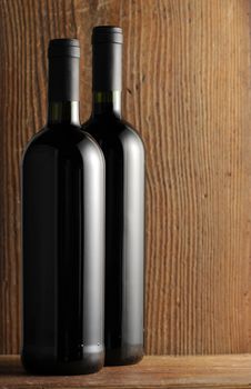 two bottles of wine red on wooden background, set on a wooden shelf