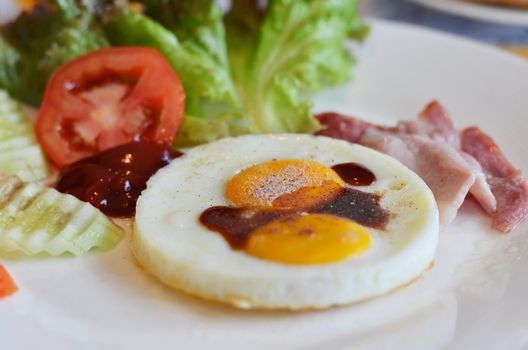 american style breakfast , with bacon, fried egg and fresh vegetables