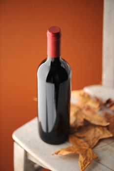 red wine bottle on a white wooden chair