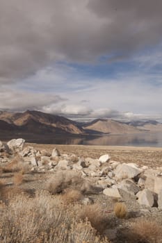 A lonely highway by a desert mountain range and lake