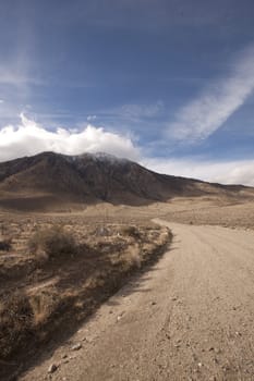 A lonely highway by a desert mountain range and lake