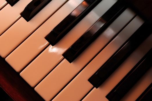 Piano keys close up using warm photo filter. Playing with light.