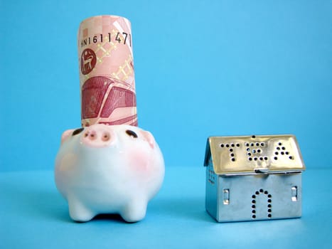 a house beside with money and piggy, metaphors for banking, finance