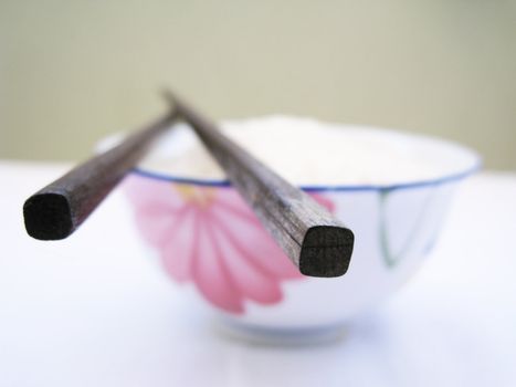 close up for a chop stick on top of bowl, chinese style kitchenware