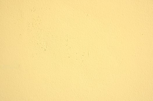 Wall painted in vivid yellow color. Photo texture.