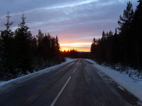 Sunset at a road in the Swedish wilderness.