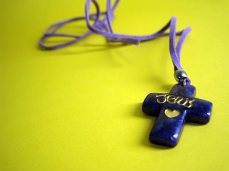 a cross necklace with jesus love curving on it 