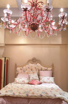 Interior of luxurious bedroom with red chandelier from crystal