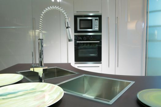 modern metallic sink with graceful tap and plate on the super-modern kitchen