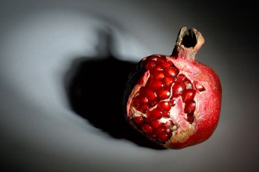 Ripe pomegranate in a ray of light