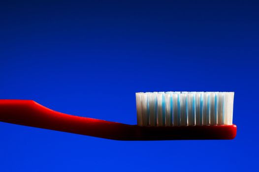 Red tooth-brush on a dark blue background