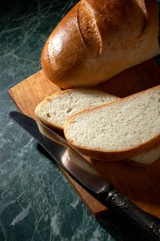 White loaf and knife on a marble kitchen table