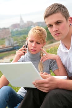 young man with laptop and beautiful girl with mobile phone