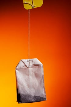 Tea bag on an dark orange background