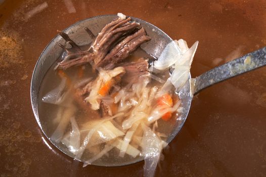 Ladle with meat in a saucepan with a russian cabbage soup