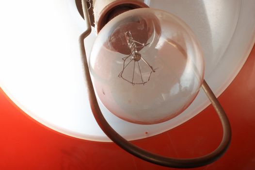 Electric bulb under a red lamp shade