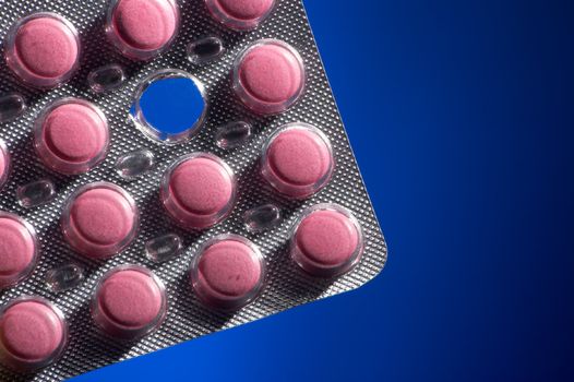 Pink tablets on a dark blue background