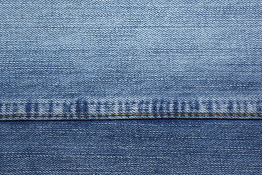 Blue jeans with yellow stitches as background or backdrop.