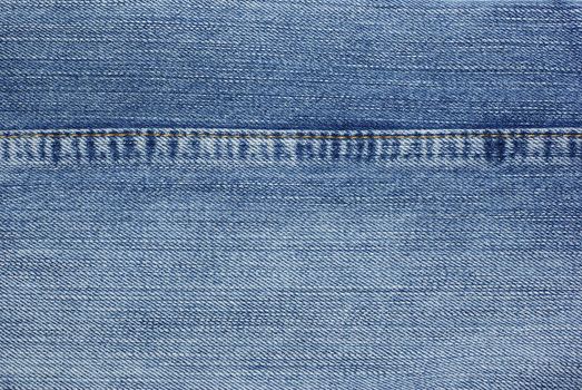 Blue jeans with yellow stitches background.