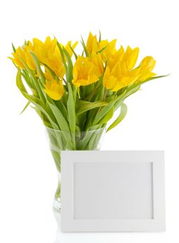 yellow tulips in a vase and photo frame on a white background